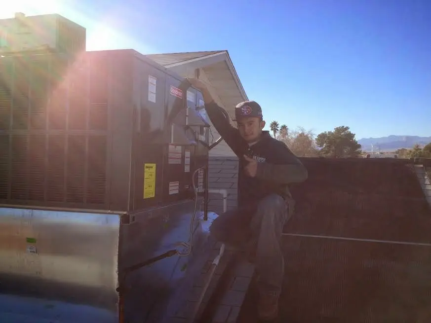 HVAC technician performing AC Tune-Up on a rooftop unit in Bloomsburg