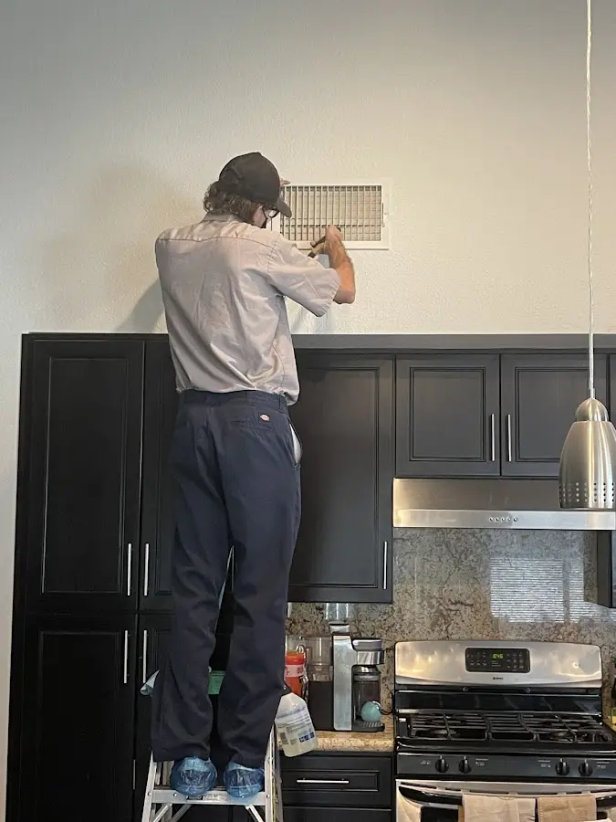 Technician inspecting an air vent during HVAC service in Bloomsburg